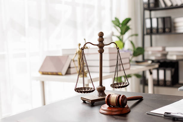 Scales of justice and a gavel on a desk.